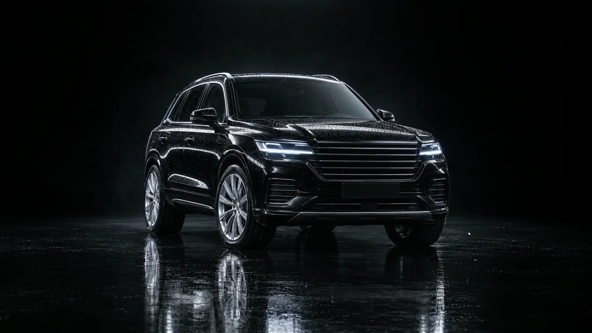 A freshly valeted black SUV, still wet, under studio light