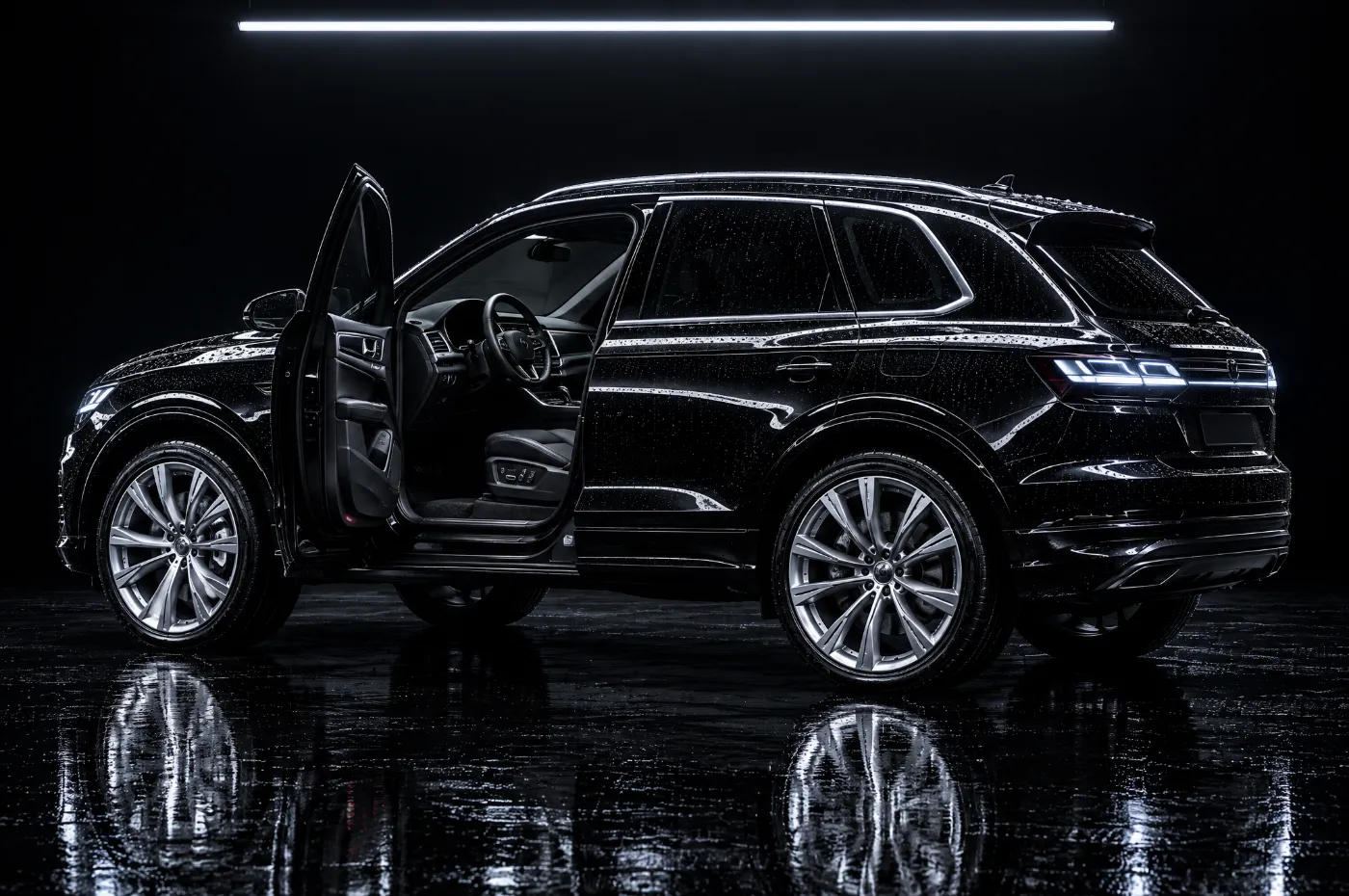 A clean black SUV with the driver's door open on a spotless interior