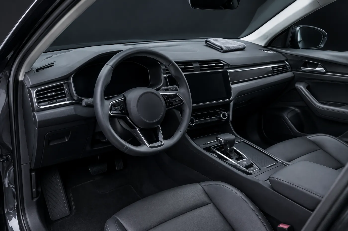 A clean car interior with a folded microfibre cloth on the dashboard