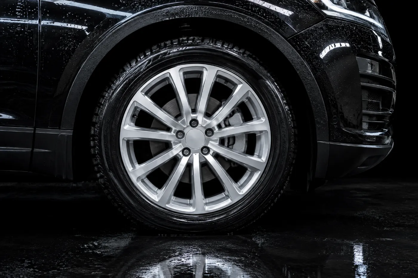 A clean alloy wheel and dressed tyre on a black SUV